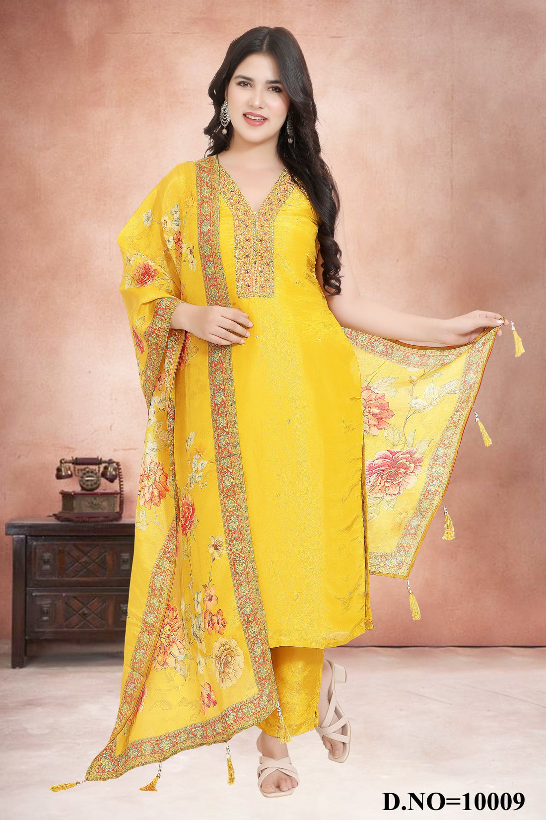 Woman wearing a yellow traditional outfit with floral patterns against a pink background